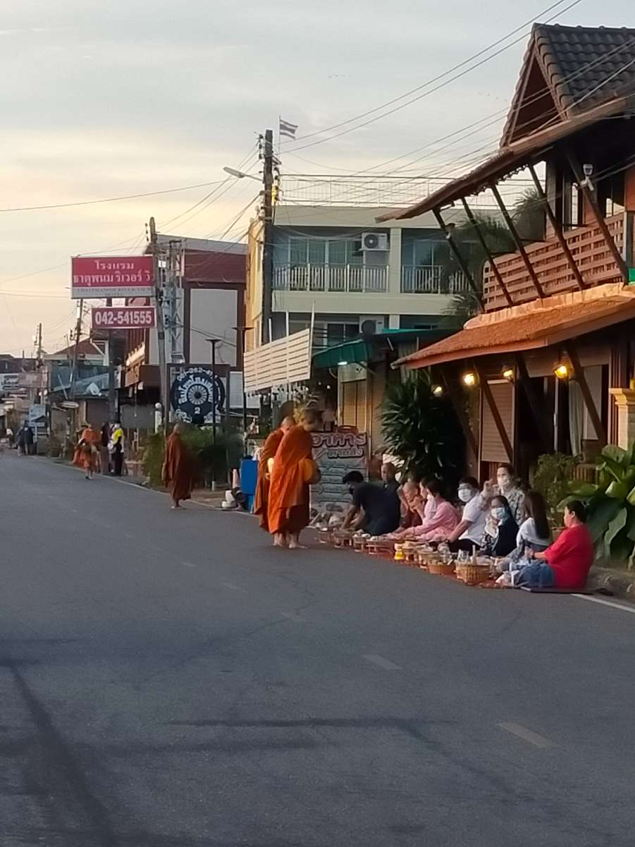 หลังจากที่เราใส่บาตรชุดแรกเสร็จ สังเกตุพระทิ้งช่วงห่าง หลังจากนี้ครูกนก ฯ เจ้าของรีสอร์ทบอกว่ายังมีคณะใหญ่จากวัดพระธาตุพนม จะเดินมารับบิณฑบาตรประมาณเจ็ดโมงกว่านิด ๆ เราจึงถือโอกาสเดินออกไปปากซอยไปชมพระอาทิตย์ขึ้นที่ริมโขง พบว่ามีบรรดานักท่องเที่ยวและชาวบ้านพากันรอใส่บาตรอยู่ริมถนนกันเยอะเลย อนุโมทนาสาธุ สาธุ ครับ